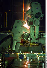 Astronausts work on Hubble in the Shuttle Payload Bay
