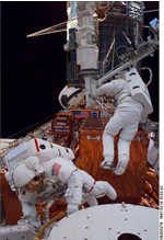 Astronausts work on Hubble in the Shuttle Payload Bay