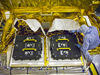 Technicians install Hubble's new flight batteries onto the SLIC in the PHSF at the Kennedy Space Center, FL.