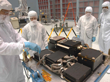 Technicians prepare the replacement SIC&DH for testing in a large clean room at the GSFC